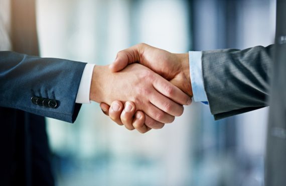 Closeup shot of two businessmen shaking hands in an office